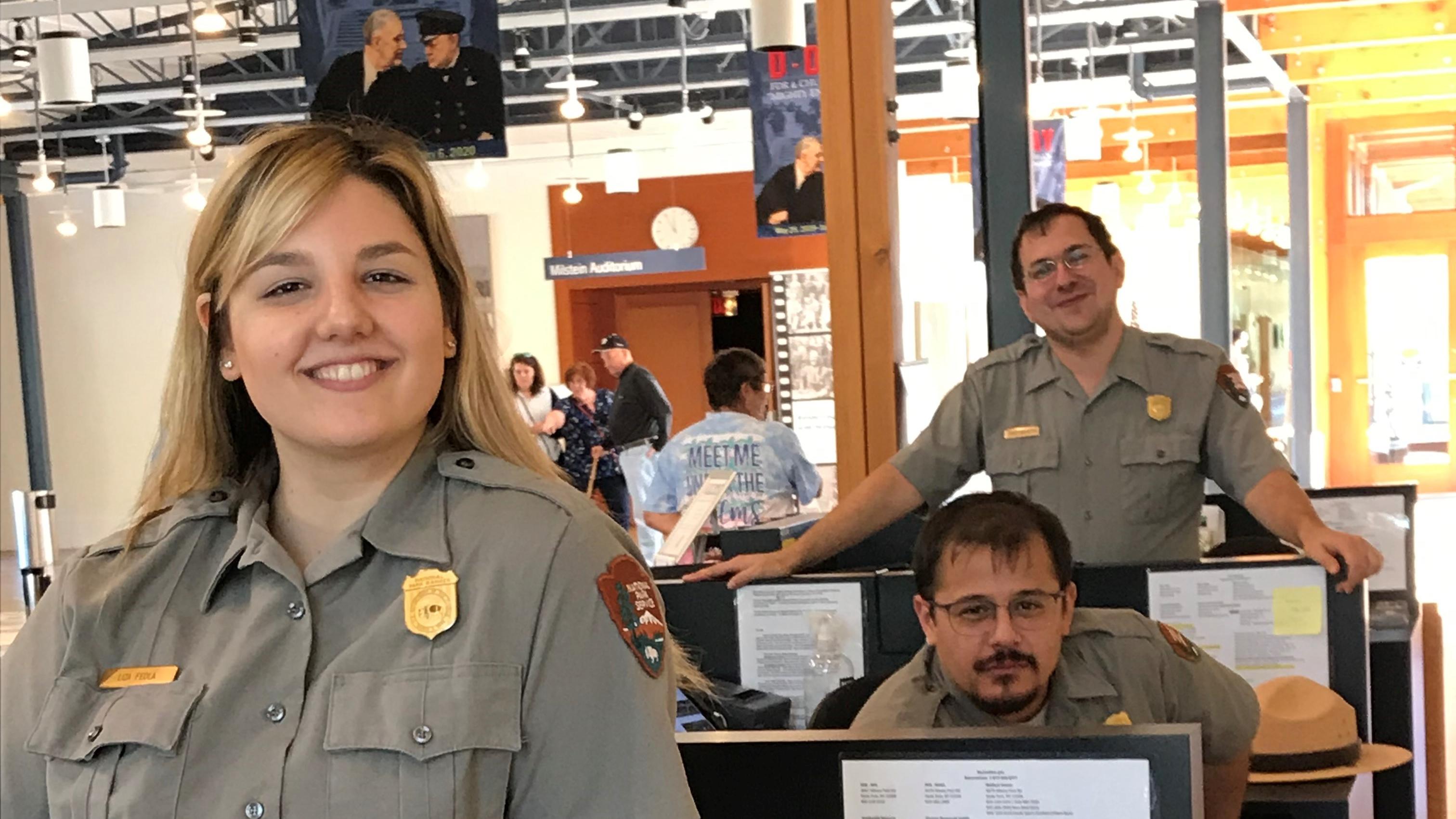 Three park rangers at a desk.