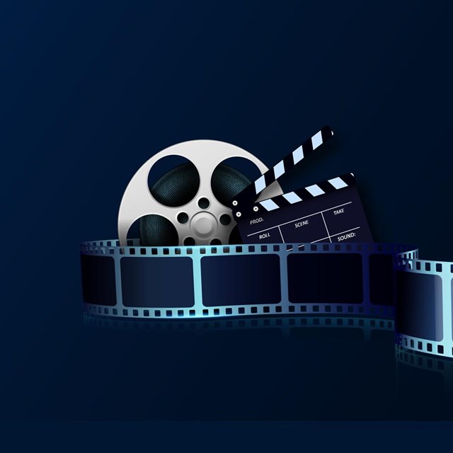 A graphic of a movie strip, film canister and action slate.