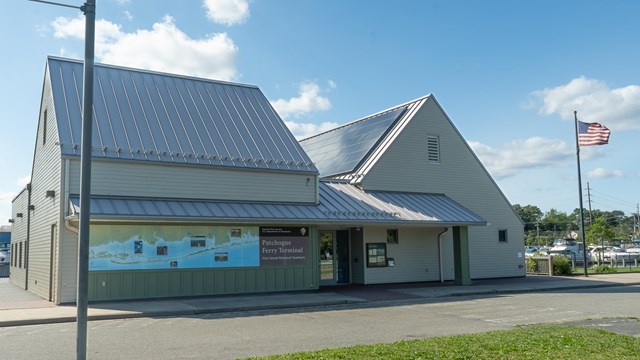 A building with a sign reading "Patchogue Ferry Terminal" displaying a map.