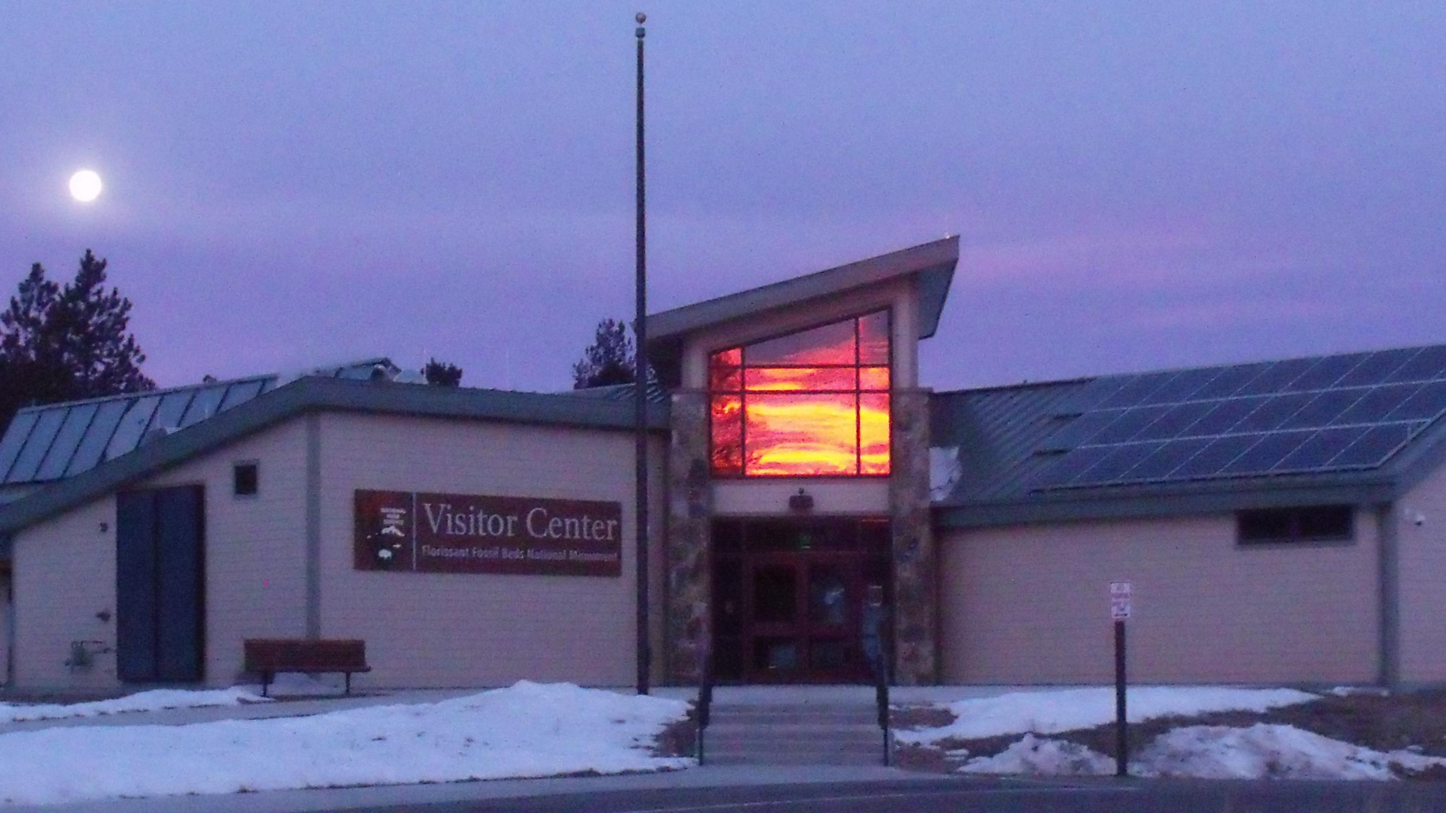 A building at dusk with the sunset reflected in the windows