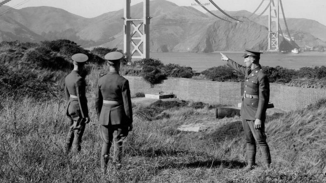 Soldiers at Fort Point with the construction of the Golden Gate Bridge in the background.