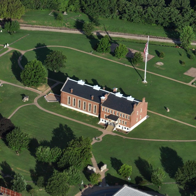 An aerial image of the red brick visitor center and the oval path around the parade grounds.