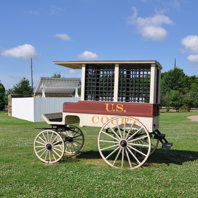 The red and white court wagon standing in front of the gallows.