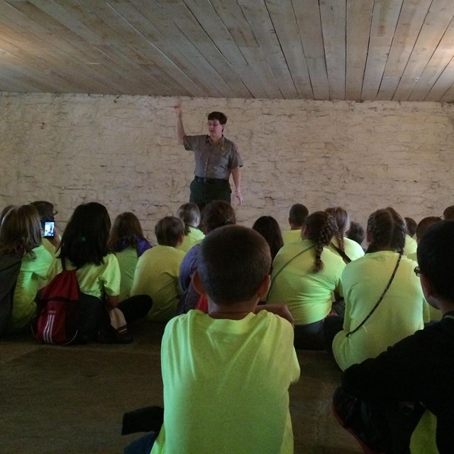 Park Ranger talking to students in the basement jail.