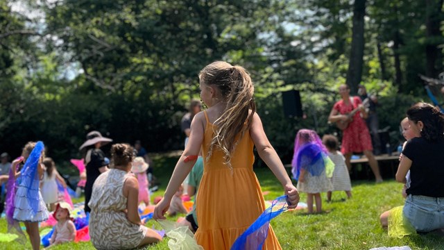 Child holds blue and gold flags during children's concert 