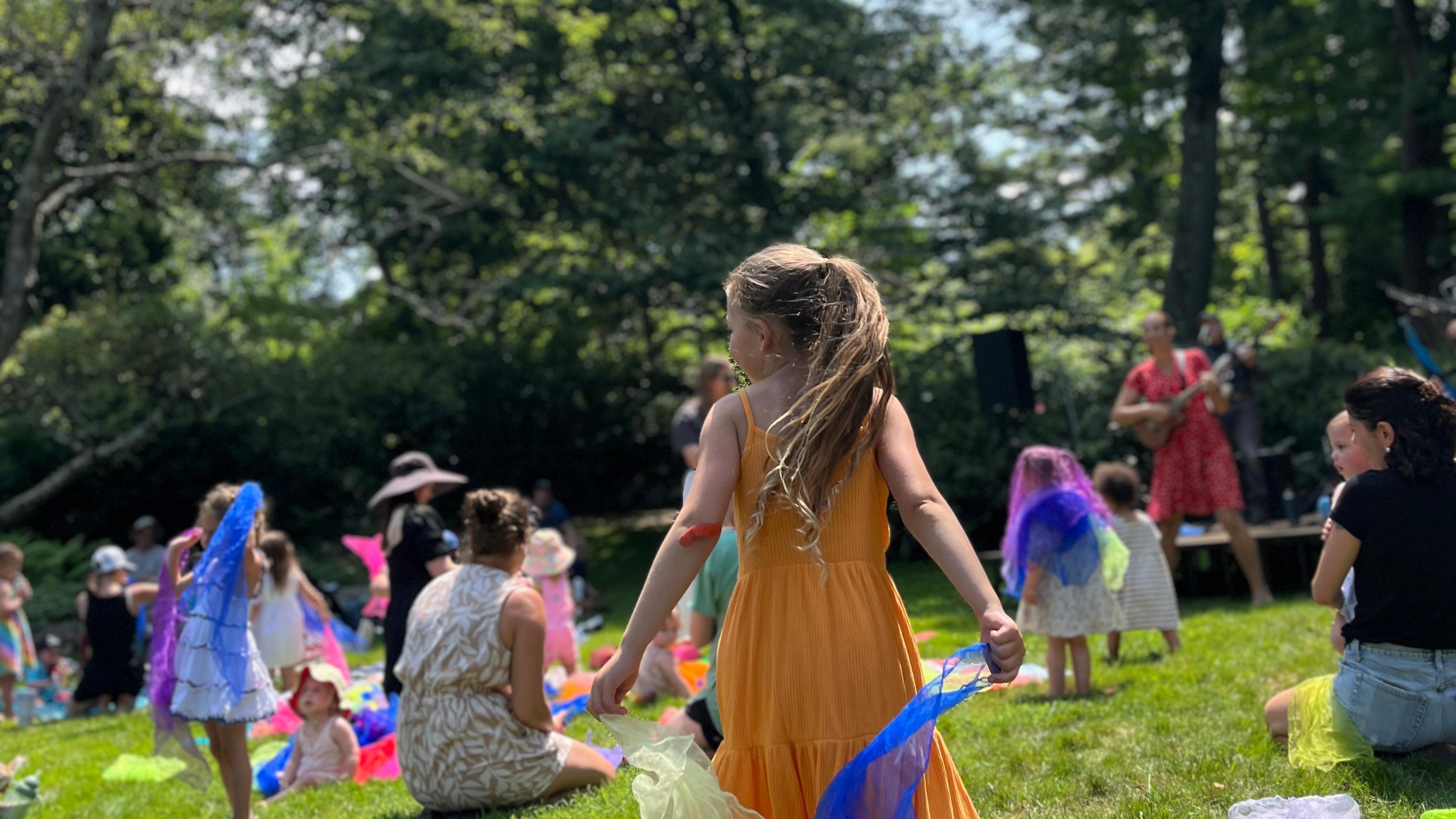 Child waving colorful flags at a concert on the South Lawn. 