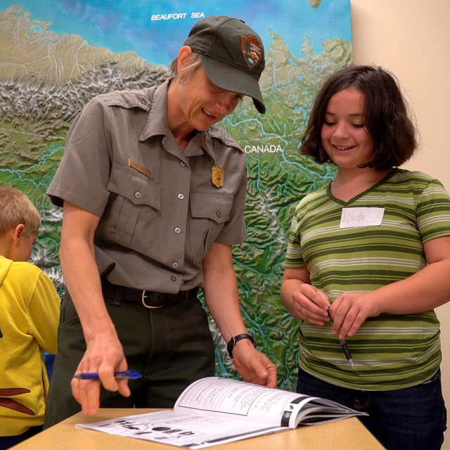 A park ranger shows a child insects.