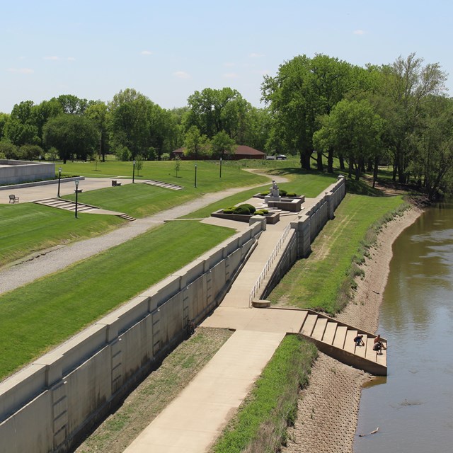 A concrete ramp descends along the river side of the levee wall do the Lower Levee trail.