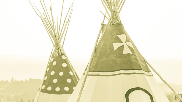 Two teepee lodges against the sky