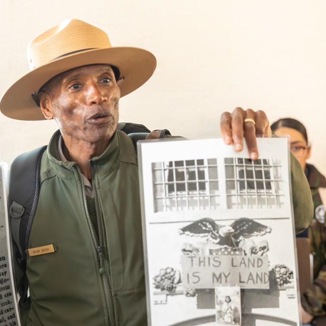 Ranger holds up a photo for students.