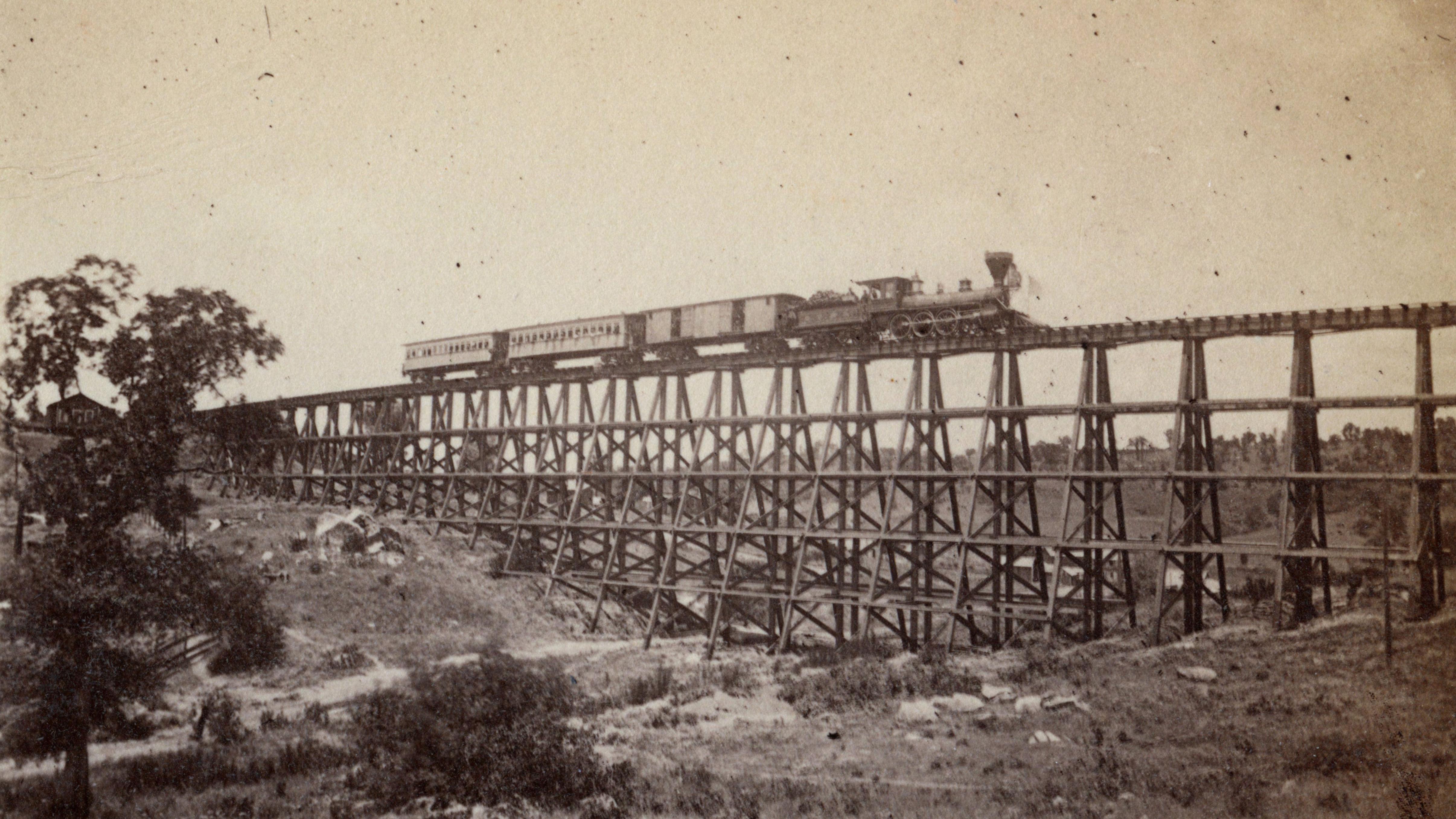 Sepia colored Locomotive traveling over Trestle over gorge