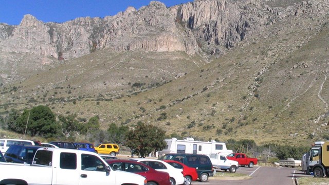 A full parking lot in a desert mountain landscape