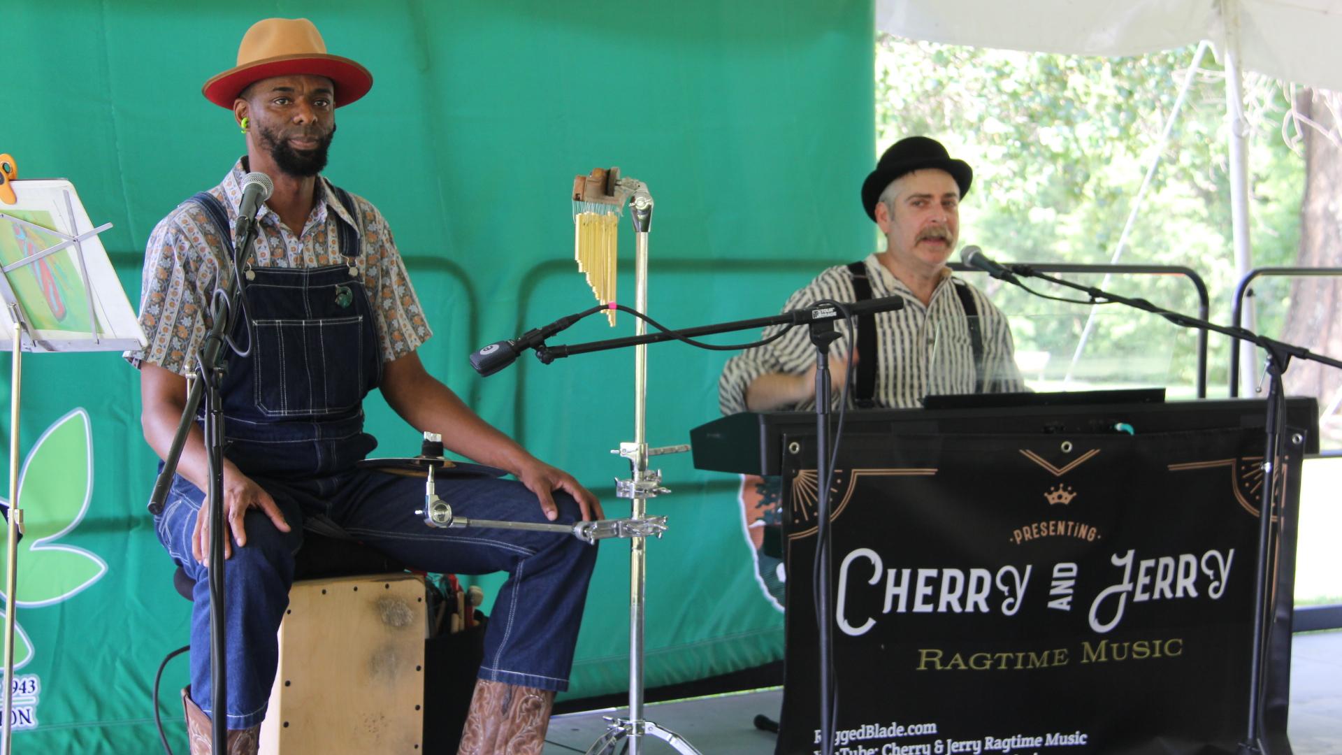 Two men playing musical instruments and telling stories. 