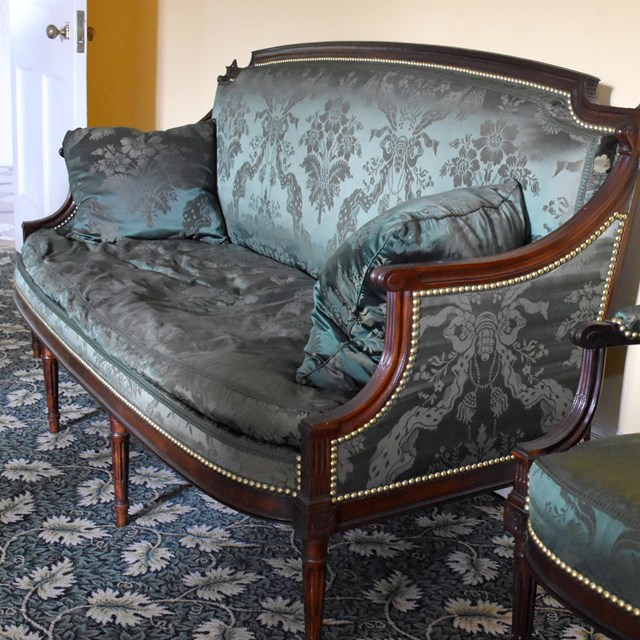A French style chair and couch upholstered in green silk.