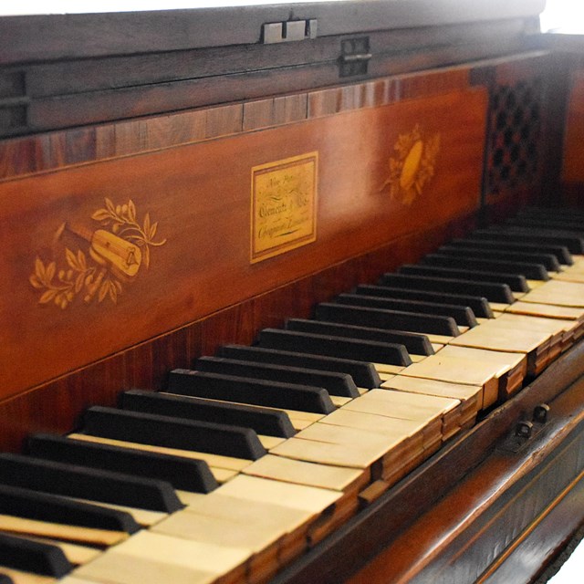 An old piano with brown wood. 