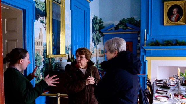 Image of visitors talking to a Ranger inside of the dining room at Hampton.