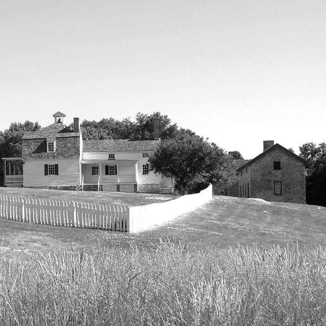 Historic black & white photo of farm side, seen is overseer's house and the quarters of the enslaved
