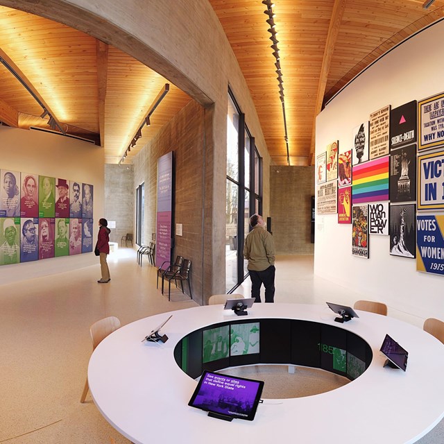 A large exhibit room with wooden ceilings and posters on the wall.