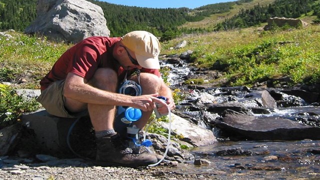 Man filters water from stream