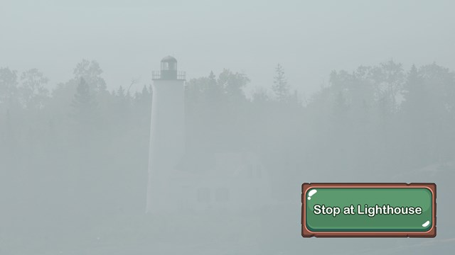 Close up of a foggy lighthouse from the water.