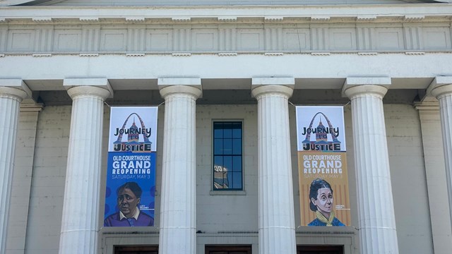 white columned building with green dome and colorful banners