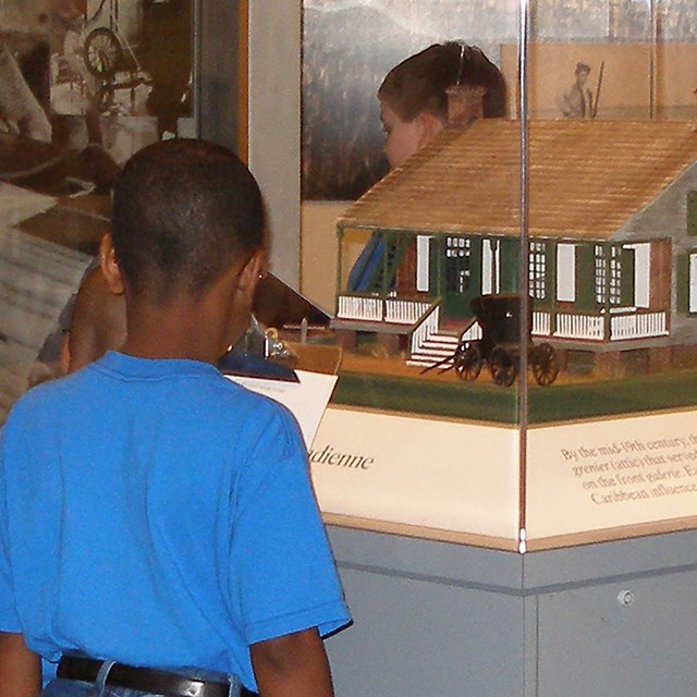 Boys looking at model of old house