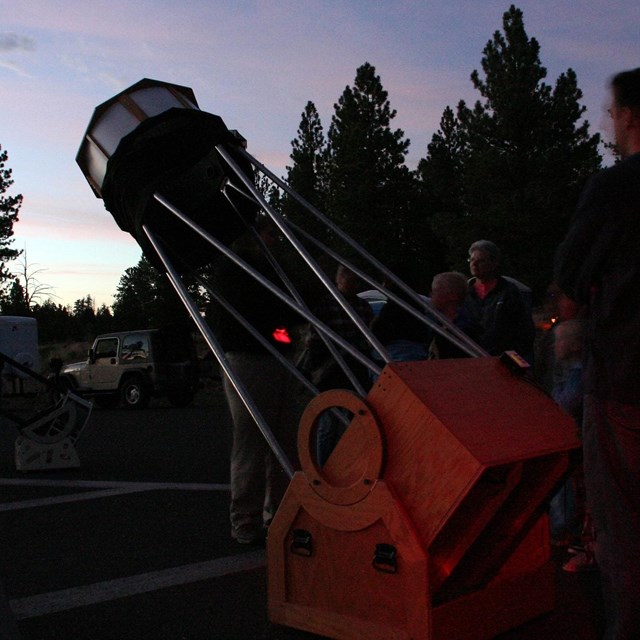A person uses a telescope to view the night sky.