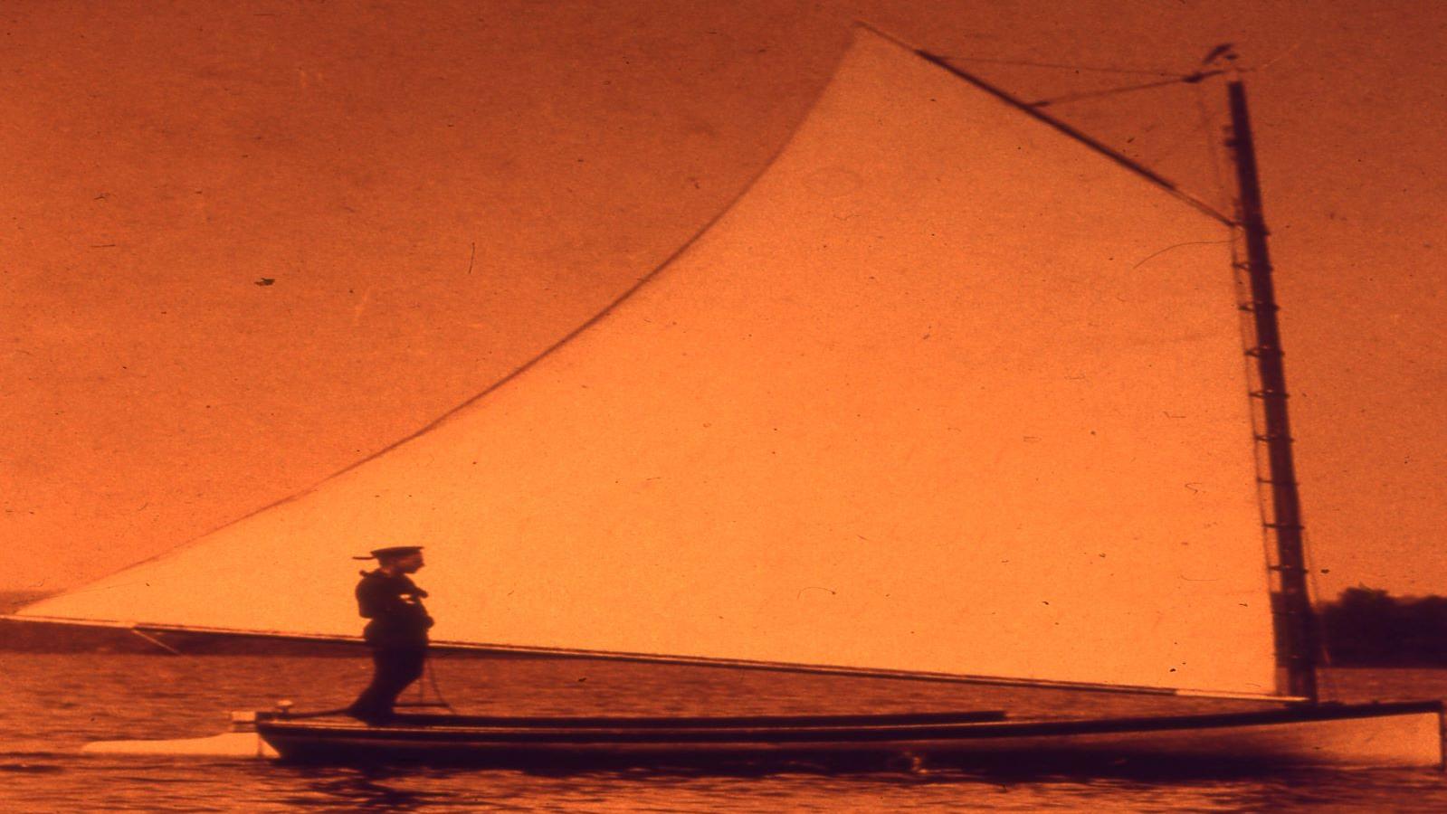 A man on a sailboat on a lake