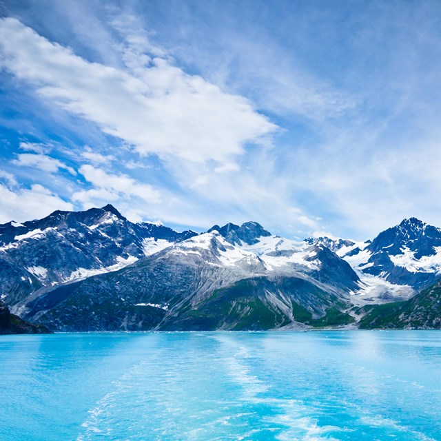 Icy waters lead up to a range of mountains. 