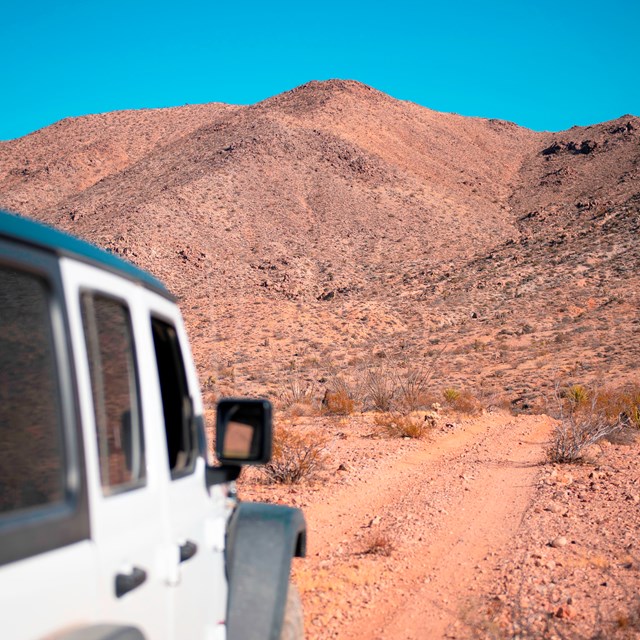 A jeep driving on a dirt road