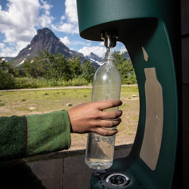 a water bottle filling station is used to refill a water bottle