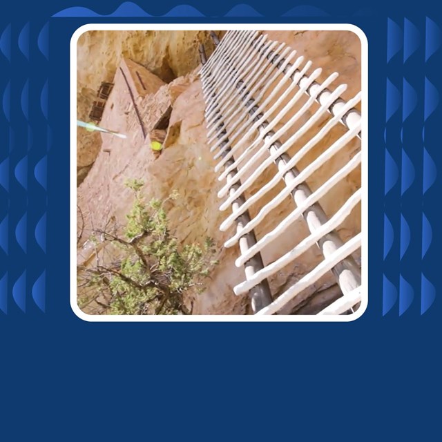 Photo of wooden ladder against red sand stone wall. 
