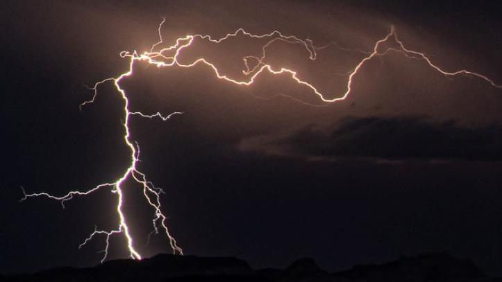 A lightning bolt strikes on a dark night.