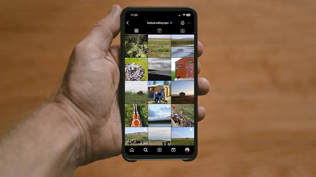 Hand holding phone with screen open to Kobuk Valley Instagram Page