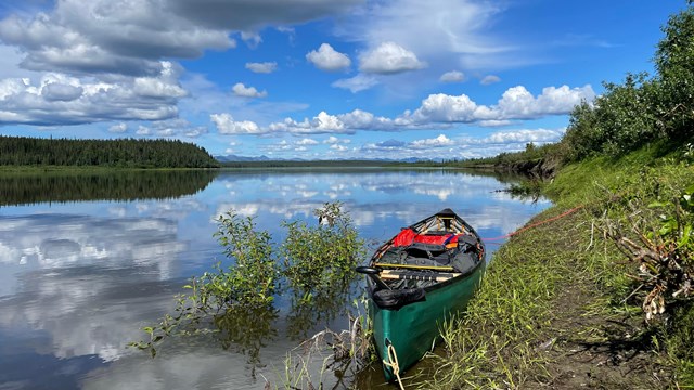 Kayak boat sitting on Kobuk river on a sunny day 