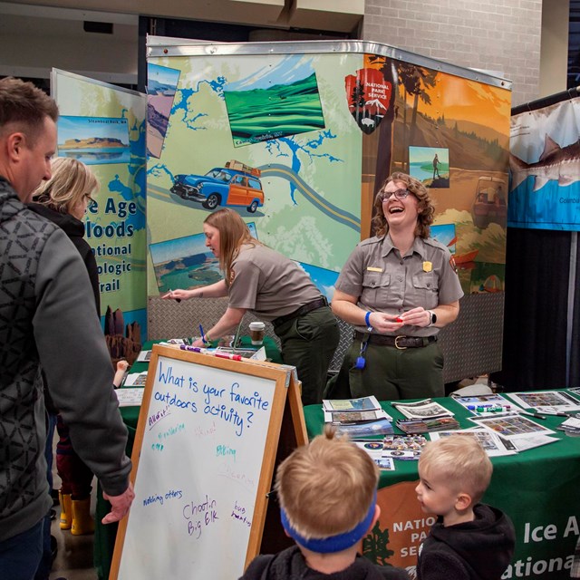 Two rangers interact with visitors at an outreach event