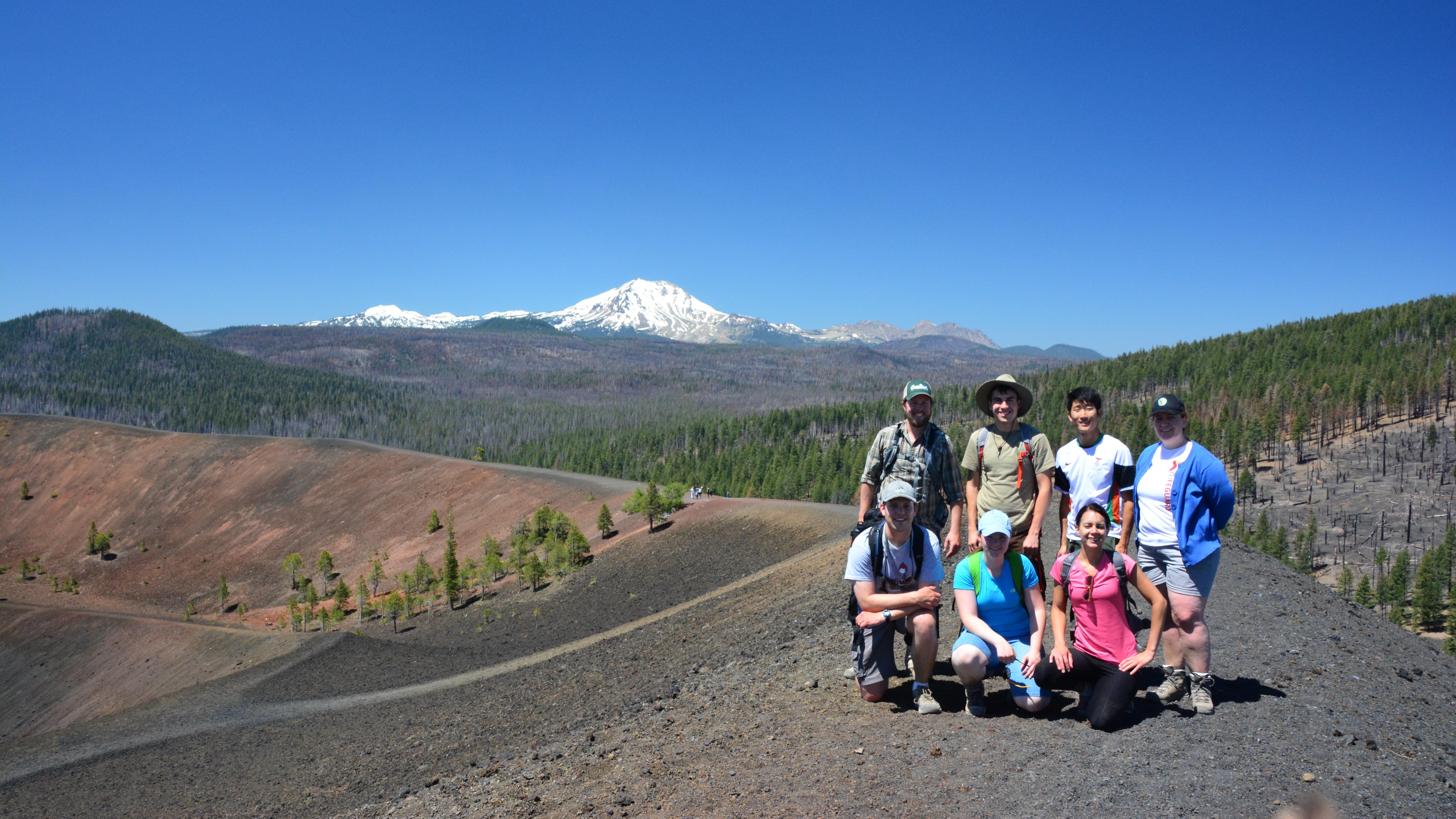  A group of hikers pose for a photo on the summit of a volcano