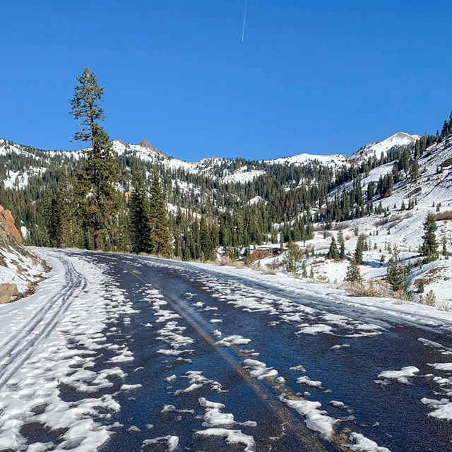 Photo of a highway winding along a mountainside dusted with snow.