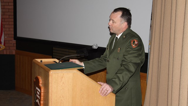 Park Ranger standing at podium in front of a screen