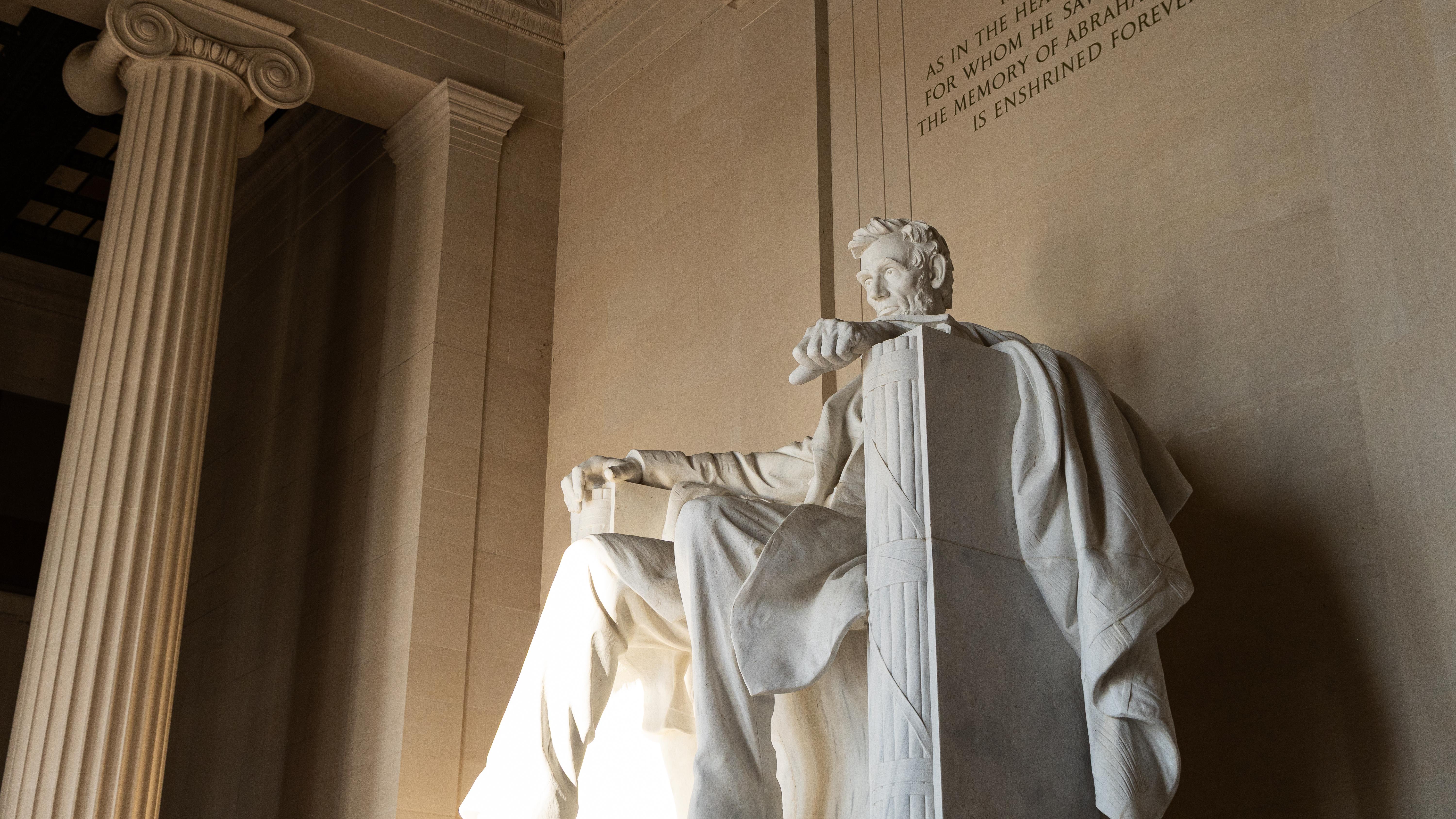 A large statue of Abraham Lincoln inside a tall room with columns.