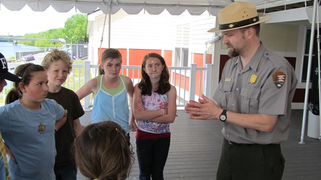 A park ranger works with a students outdoors along the river