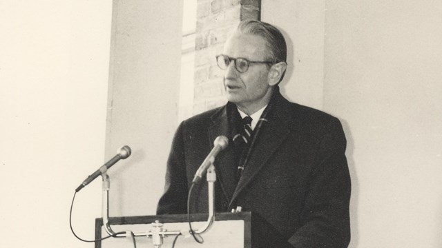 Laurence Rockefeller stands at a podium and delivers a speech at the opening of the Woodstock Inn