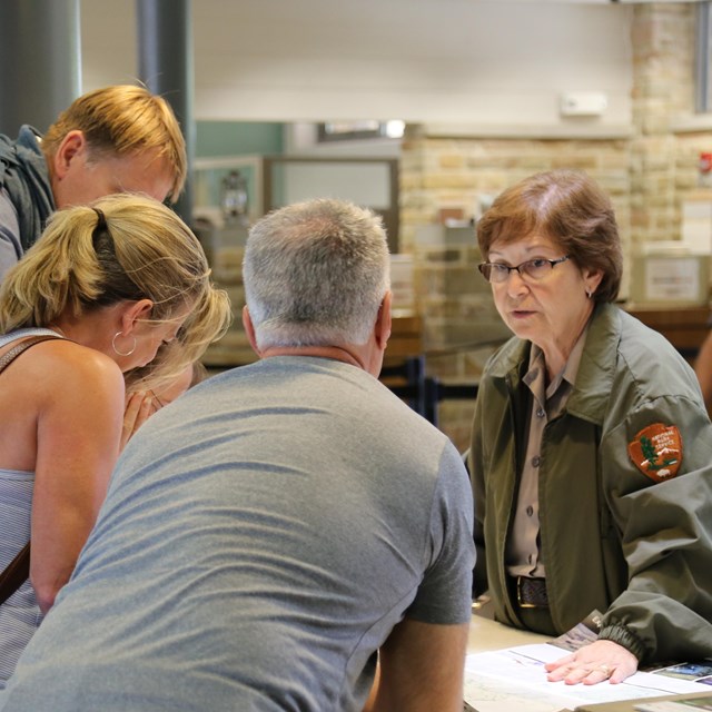 Inside the Mammoth Cave Visitor Center, a ranger answers visitors' questions at the info desk.