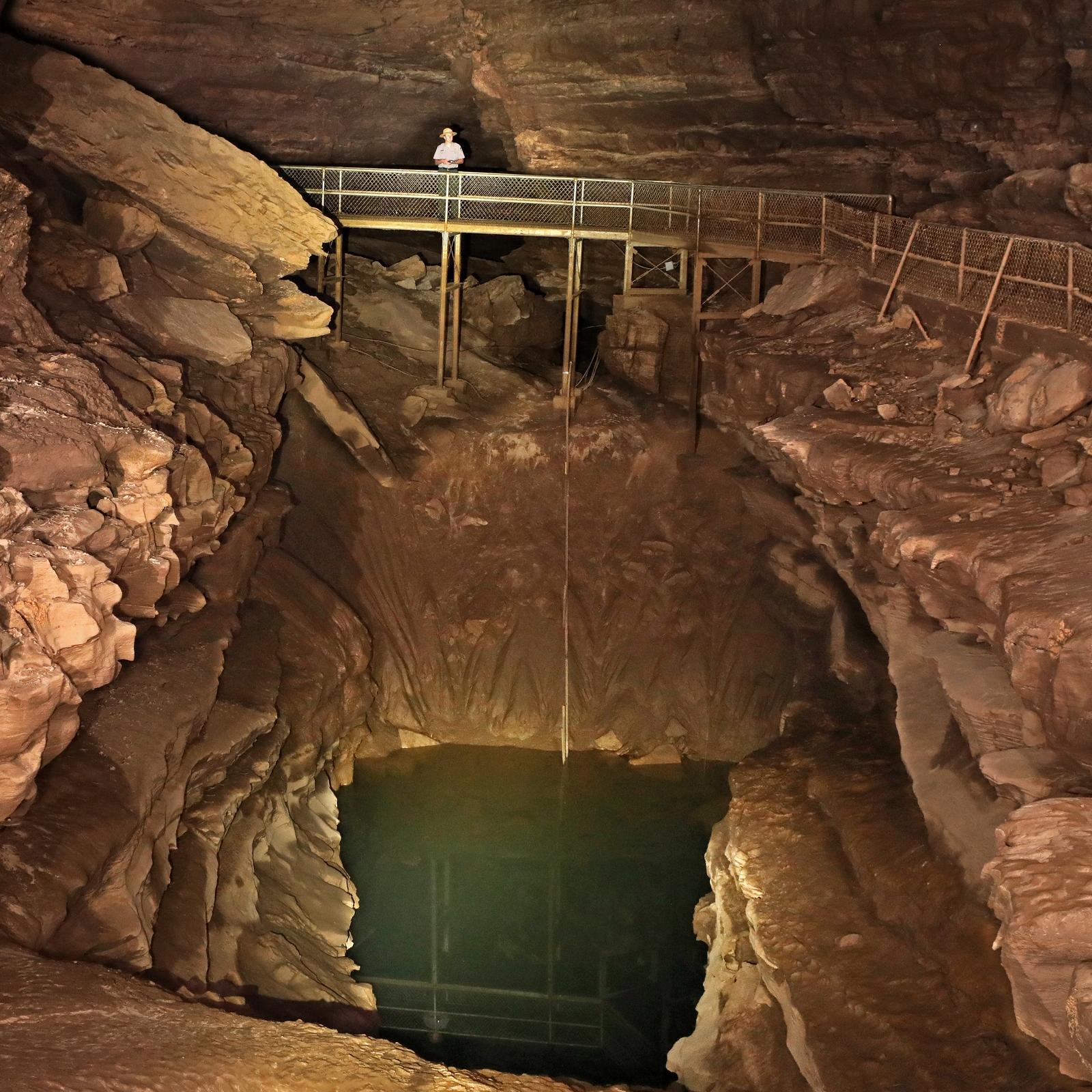 A small pool of water in a cave passage. 