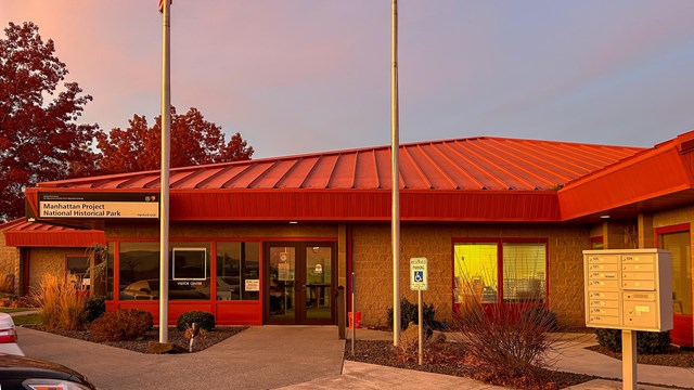 Red-roofed single-level building in warm sunset light - Hanford site Visitor Center