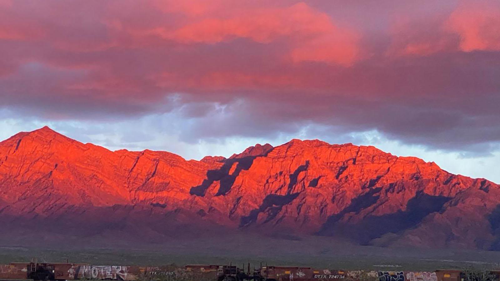 Mountains in the desert with a reddish glow from the sunset.