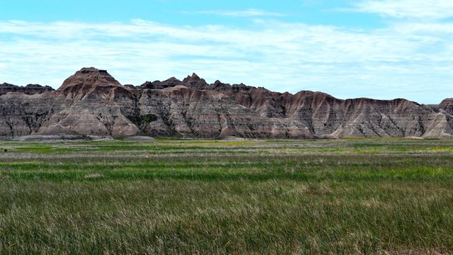 eroded rocky bluffs with grassland in foreground