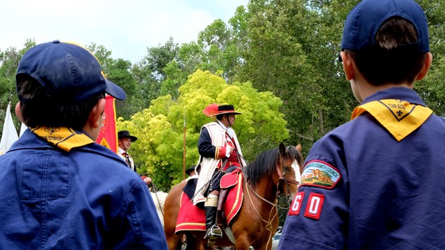 Boy Scouts looking towards Anza Expedition reeanctors on horseback