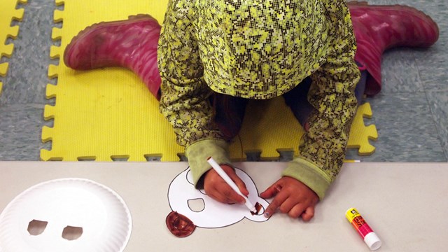 Kid coloring a face mask