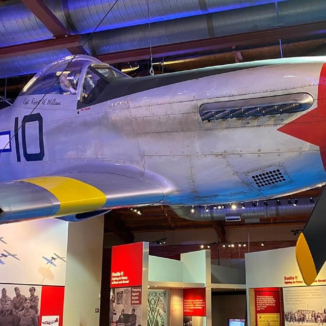 Historic P-51 Mustang airplane hanging in a museum